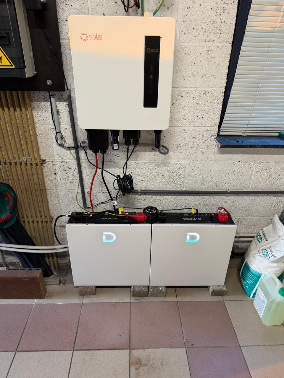 Solis omvormer boven twee Dyness batterijmodules in een Vlaamse berging