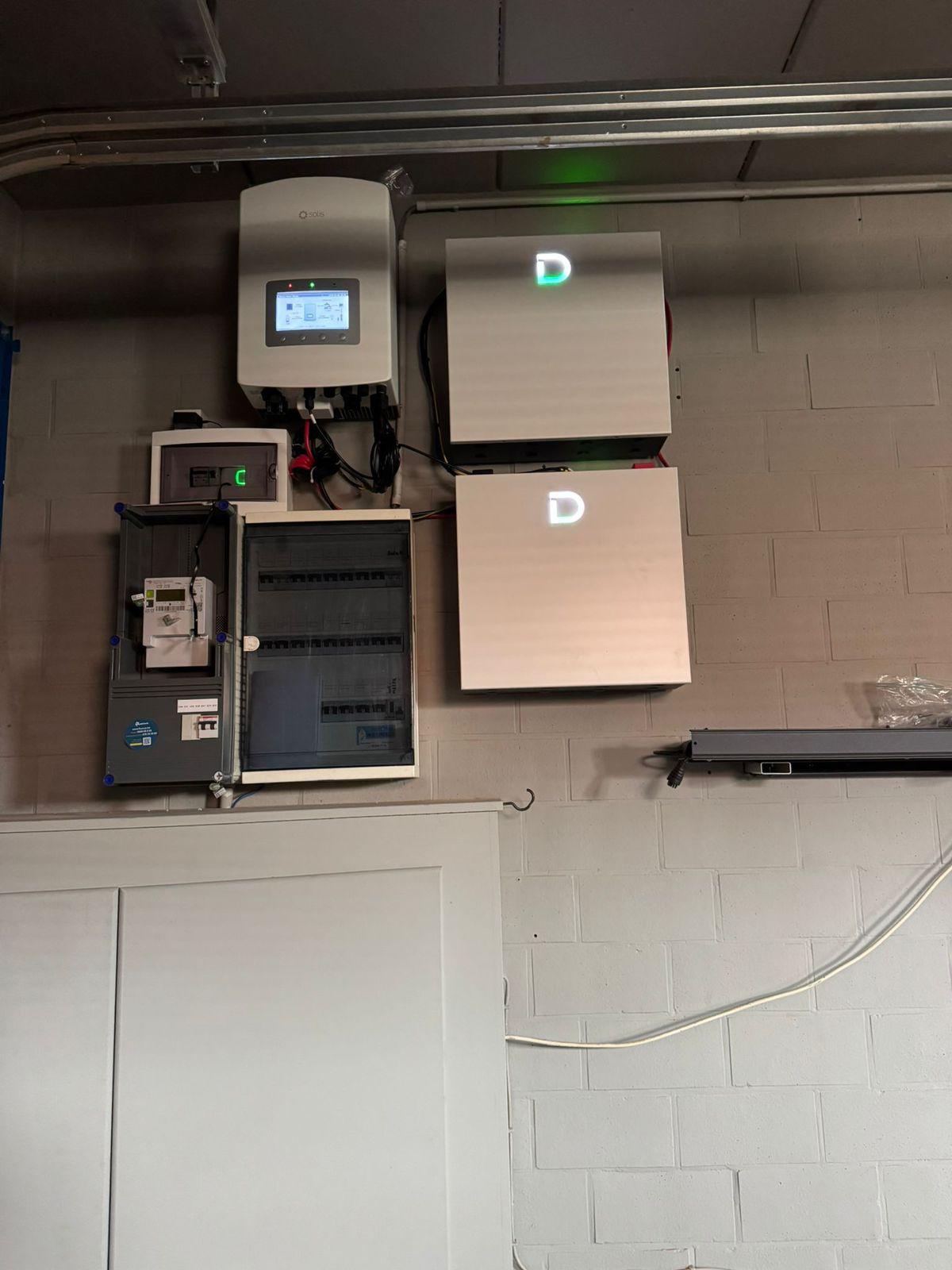 Volledige installatie met Solis omvormer, digitale meter, zekeringkast en twee Dyness batterijmodules aan de muur